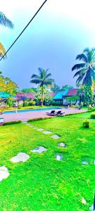 a green field with stepping stones in the grass at Sana Villa & Resort Goa in Anjuna