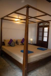 a bedroom with a four poster bed in a room at Laguna Beach Garden in Uswetakeiyawa