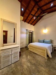 a bedroom with a bed and a large mirror at Laguna Beach Garden in Uswetakeiyawa