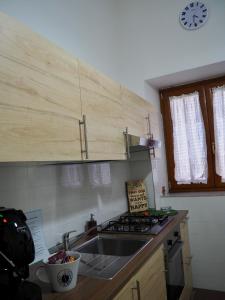 a kitchen with a sink and a clock on the wall at Casa Martina in Castellammare di Stabia