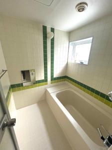 a bathroom with a bath tub and a window at Nature Moiwa in Sapporo +20 photos