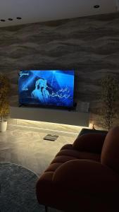 een woonkamer met een bank en een flatscreen-tv bij Elegant studio in Riyad +5 foto's