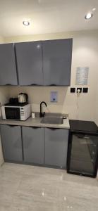 een keuken met een spoelbak en een magnetron bij Elegant studio in Riyad