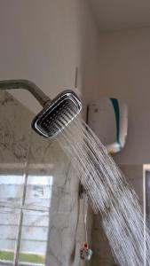 a stream of water coming out of a shower at Nova Nest near Infocity Patia - Couple friendly in Bhubaneshwar