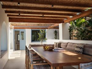 uma sala de jantar com mesa e cadeiras de madeira em Liostasi Ona Villa em Ios Chora