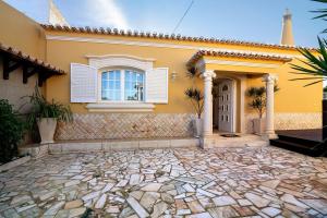 una casa gialla con una finestra e un vialetto in pietra di Casa da Várzea a Roja- Pé