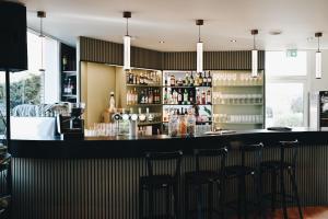 a bar with four stools in a restaurant at Hôtel Nova Adult Only- Villefranche sur Saône in Limas +15 photos