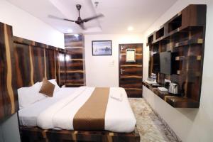 Best Buy Hotel في كولْكاتا: غرفة نوم مع سرير كبير وتلفزيون +6 صور