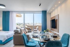 a living room with a couch and a table and chairs at Offshore Suites Apartments in St Julians Centre in St Julian's