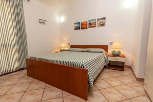 a bedroom with a bed and two night stands and two lamps at Rosmarino veranda and pool with sunset view in Costa Paradiso +15 photos