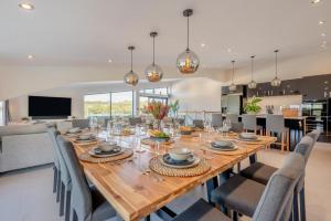 een eetkamer met een lange houten tafel en stoelen bij 12 Bed in Pancrasweek oc-lvbb24 in Pancrasweek