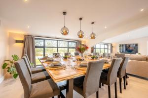 een eetkamer met een grote houten tafel en stoelen bij 12 Bed in Pancrasweek oc-lvbb24 in Pancrasweek