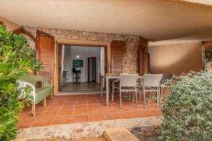 a patio with chairs and a table on a patio at Rosmarino veranda and pool with sunset view in Costa Paradiso