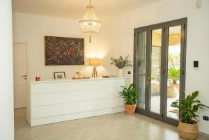 a living room with a white cabinet and potted plants at B&B Machiavelli in Gallipoli