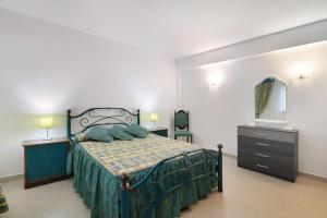 una camera da letto con un letto, un comò e uno specchio di Casa da Várzea a Roja- Pé Altre 40 foto