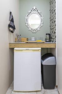 baño con tocador con espejo y cubo de basura en En-suite, private room, free WIFI in Plett, en Plettenberg Bay