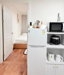 a white kitchen with a refrigerator and a bed at 루나스테이 in Seoul +47 photos
