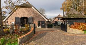 a brick house with a gate and a fence at Op Vakantie bij Nicole in Putten