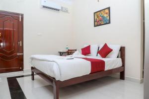 蓬蒂切里MP Villa的卧室里有一张床，上面有红色和白色的枕头