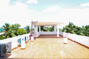 蓬蒂切里MP Villa的房子阳台上有一架梯子和棕榈树