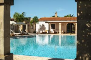 a swimming pool in front of a house at Tenuta Masseria & Spa Chicco Rizzo in Sternatia