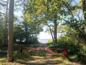 um portão vermelho em um caminho que leva à praia em 7 person holiday home in Asnæs-By Traum em Asnæs