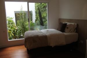 a bedroom with a bed and a large window at Casa Hotel Boyaca Real in Bogotá