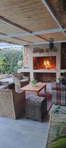 Un patio con chimenea y una mesa y sillas. en KayaLami, en Oudtshoorn