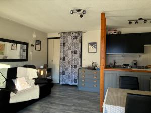 a living room with a couch and a kitchen at Parc des Ecrins 05290 Les MAISONNETTES APPARTEMENT 4 Pers in Puy-Saint-Vincent