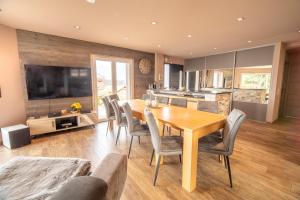 a kitchen and dining room with a wooden table and chairs at Chalet Horizon 200 m2 Jacuzzi et Sauna in Gérardmer