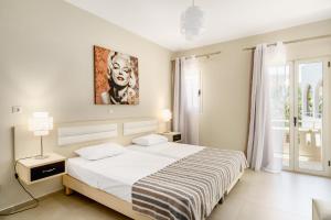 Un dormitorio con una cama y un cuadro en la pared. en Axos, en Platanes 33 fotos más