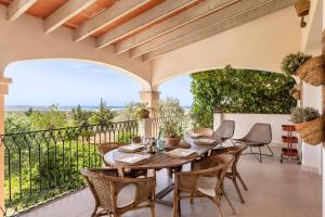 een terras met een houten tafel en stoelen bij Villa Portol in Pòrtol