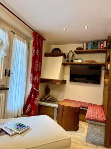 ein Zimmer mit einem Bett, einem Tisch und einem Fernseher in der Unterkunft The Courma - warm 4 family with Mont Blanc view in Verrand