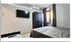 Romantic Retreat On The Lake في Nebbiuno: غرفة نوم مع سرير وتلفزيون بشاشة مسطحة