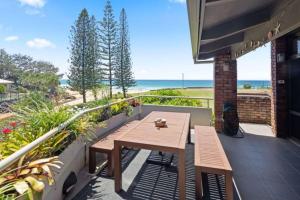 科夫斯港Nautilus Beach Resort by Charlesworth的阳台设有木桌,享有海景。