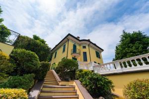 a yellow house with stairs leading up to it at Villa Aquarium in Desenzano del Garda