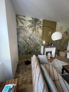 a living room with a couch and a palm mural at Maison avec Jardin 3 chambres entre Tarn et Aveyron in Carmaux