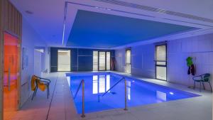 a large swimming pool with a blue ceiling at DOMITYS - La Florentine in Sarreguemines