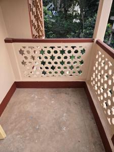 une véranda grillagée avec un mur percé d'une fenêtre dans l'établissement Indrapuri Home Stay, à Bolpur 1 autre photo