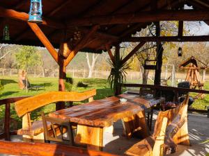 a wooden table and chairs under a pavilion at Pensiunea Cocoș in Spulber