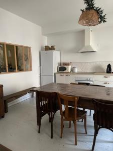 a kitchen with a table and chairs and a refrigerator at Maison avec Jardin 3 chambres entre Tarn et Aveyron in Carmaux
