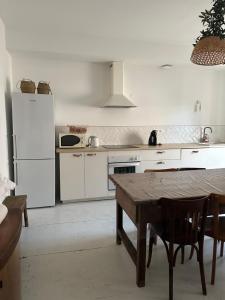 a kitchen with a table and a white refrigerator at Maison avec Jardin 3 chambres entre Tarn et Aveyron in Carmaux