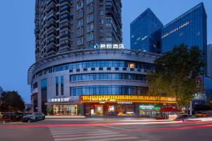 a building with a car parked in front of it at Xi Gu Hotel Wuhan Xudong Metro Station Branch in Wuhan