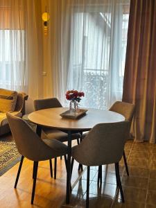 a dining table and chairs in a living room at Apartament Terra II in Floreşti