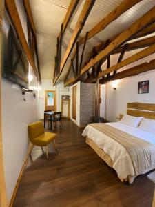 a bedroom with a large bed and a yellow chair at El Encanto del Manzano & Espacio Vittalia Spa in San José de Maipo