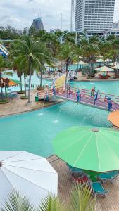 a swimming pool with an umbrella in a resort at Pattaya Park Beach Resort in Pattaya South