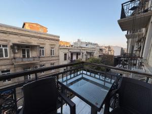 Un balcón con dos sillas y una mesa en un balcón. en Passage apart, en Baku