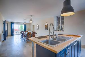 a kitchen with a sink and a table with chairs at La Maison D'hana in Saint-Bonnet-de-Valclérieux