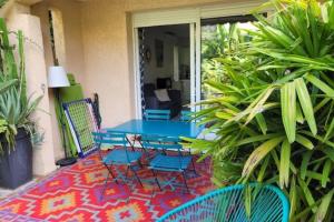 une terrasse avec une table et des chaises bleues sur un tapis dans l'établissement Nice studio 30 m with terrace and pool, à Antibes