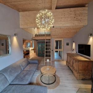 a living room with a couch and a chandelier at chalet atelier Luxuriöses Chalet mit alpinem Charme in Telfes im Stubai